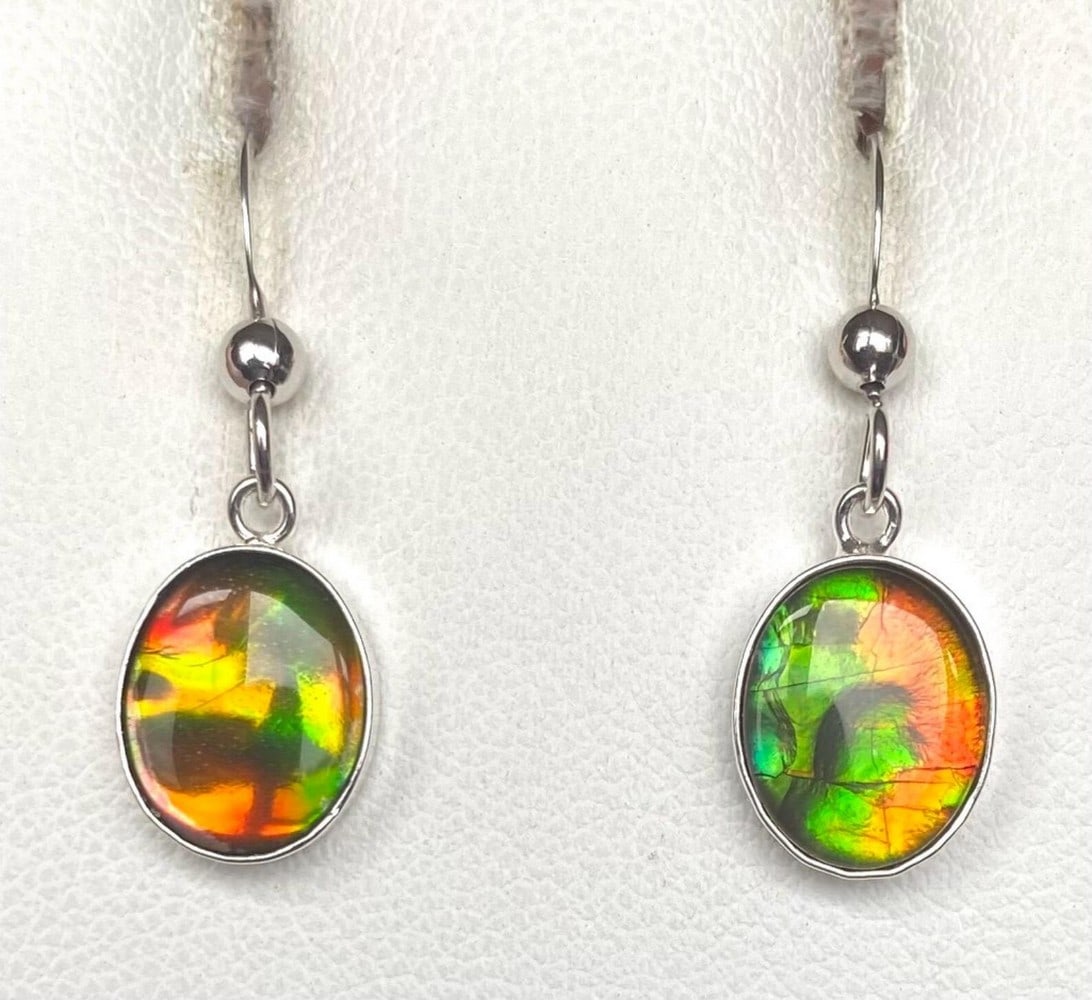 Autumn Coloured Ammolite Earrings: Autumn Coloured Ammolite Earrings These Ammolite earrings showcase vibrant autumn hues with a captivating crinkled pattern. The 10mm x 8mm low-dome quartz-capped triplets are set in sterling silver an