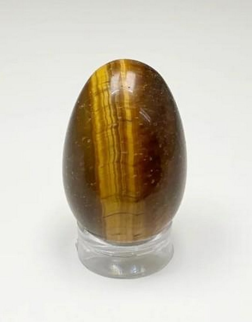 Golden Gaze Tiger Eye Mini Egg: Golden Gaze Tiger Eye Mini Egg Gleaming with warm golden and deep brown hues, the Golden Gaze Tiger Eye Mini Egg captures the mesmerizing chatoyancy of this legendary stone. Known for its protective a
