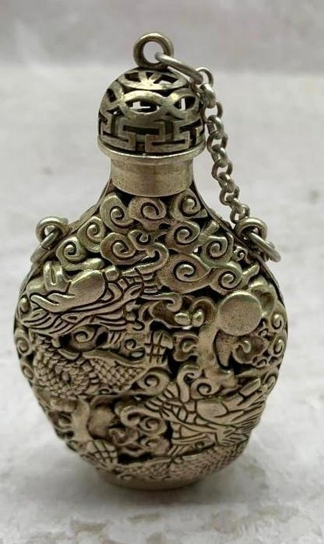 Intricately Carved Silver Snuff Bottle with Hanging Clip & Chain: Intricately Carved Silver Snuff Bottle with Hanging Clip &; Chain This beautifully crafted silver snuff bottle features an intricate design of swirling floral motifs and two finely carved dragons