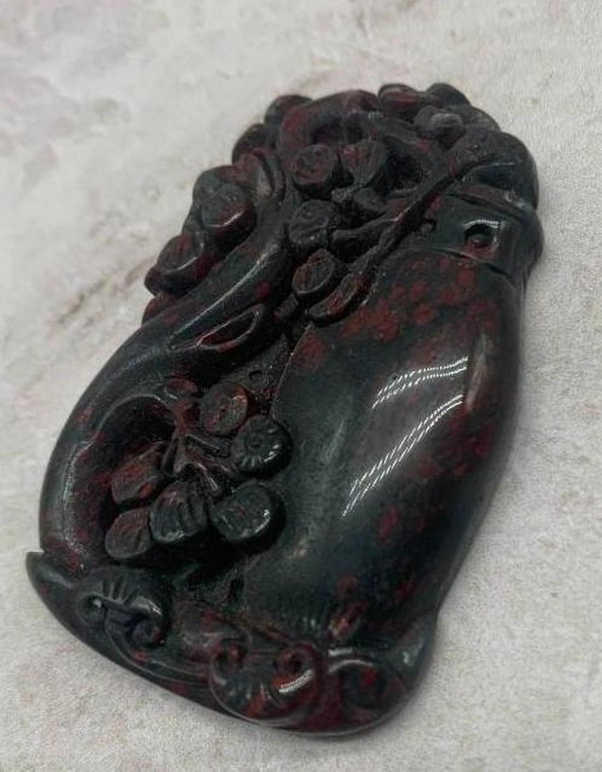 Carved Black & Red Stone Pendant with Floral Tree Motif: Carved Black &; Red Stone Pendant with Floral Tree Motif This captivating pendant showcases a beautifully carved floral tree motif set in rich black and red stone. The detailed carving brings the