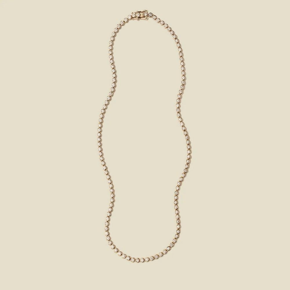 Gold Vermeil Radiant CZ Tennis Necklace: Gold Vermeil Radiant CZ Tennis Necklace Make a statement with this dazzling tennis necklace, designed to captivate. A continuous line of sparkling bezel-set cubic zirconia stones shines brilliantly,