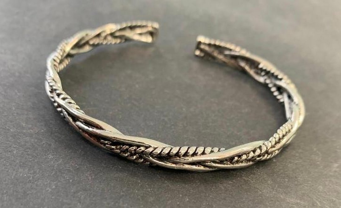 Tibetan Silver Twist-Design Bangle: Tibetan Silver Twist-Design Bangle This Tibetan silver bangle bracelet features a beautiful twist design complemented by intricate carvings along the band. The combination of textured metalwork and