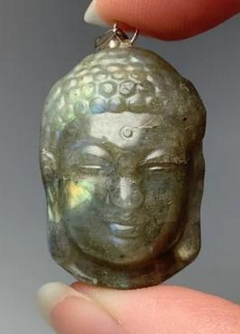 Labradorite Stone Buddha Head Pendant: Labradorite Stone Buddha Head Pendant With Sterling Silver Bail. Radiating wisdom and tranquility, this pendant is a powerful symbol of enlightenment and spiritual growth. Carved from mesmerizing labr