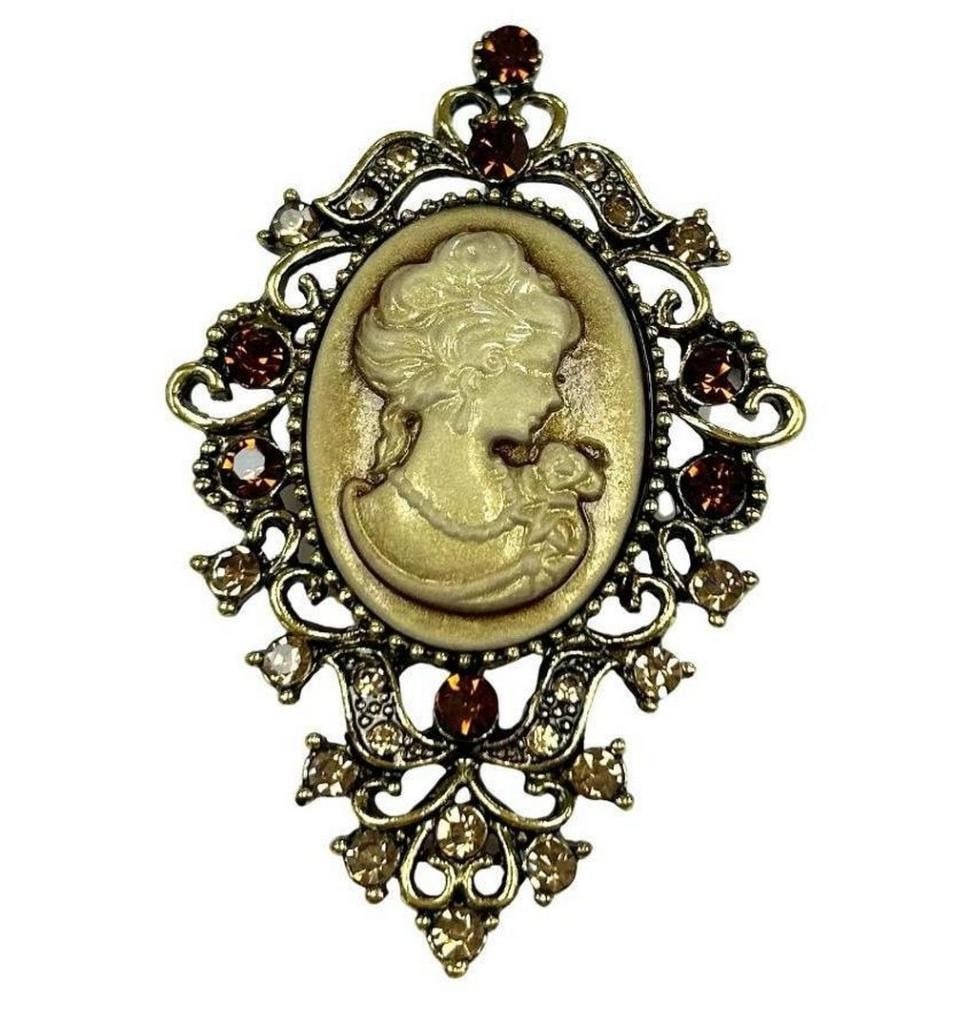 Vintage White Cameo Brooch With Orange and Peach Colored Gems: Vintage White Cameo Brooch With Orange and Peach Colored Gems This brooch is the perfect mix of classic, timeless, and elegant. Material: Crystal & Alloy Size: Approximately 2.5" L x 1.5" W