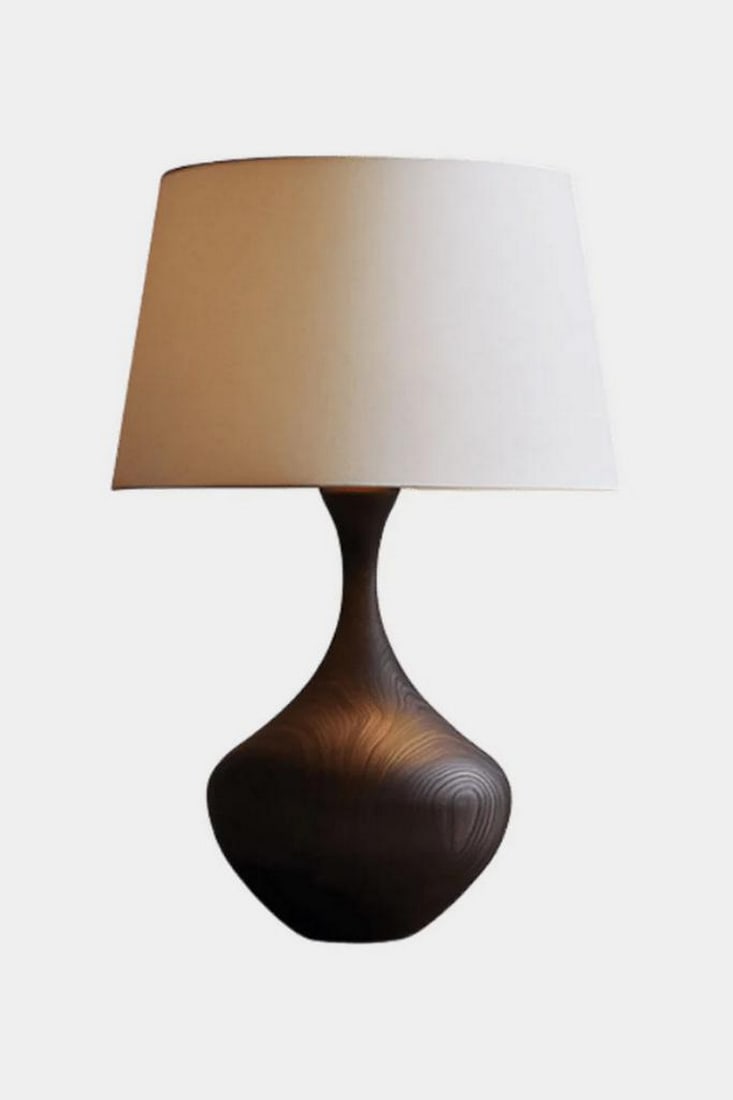 Curved Grain Wooden Table Lamp: Curved Grain Wooden Table Lamp Elegant and understated, this handcrafted table lamp features a sculptural base with flowing curves and rich wood grain textures in a deep finish. Resting on a circular 