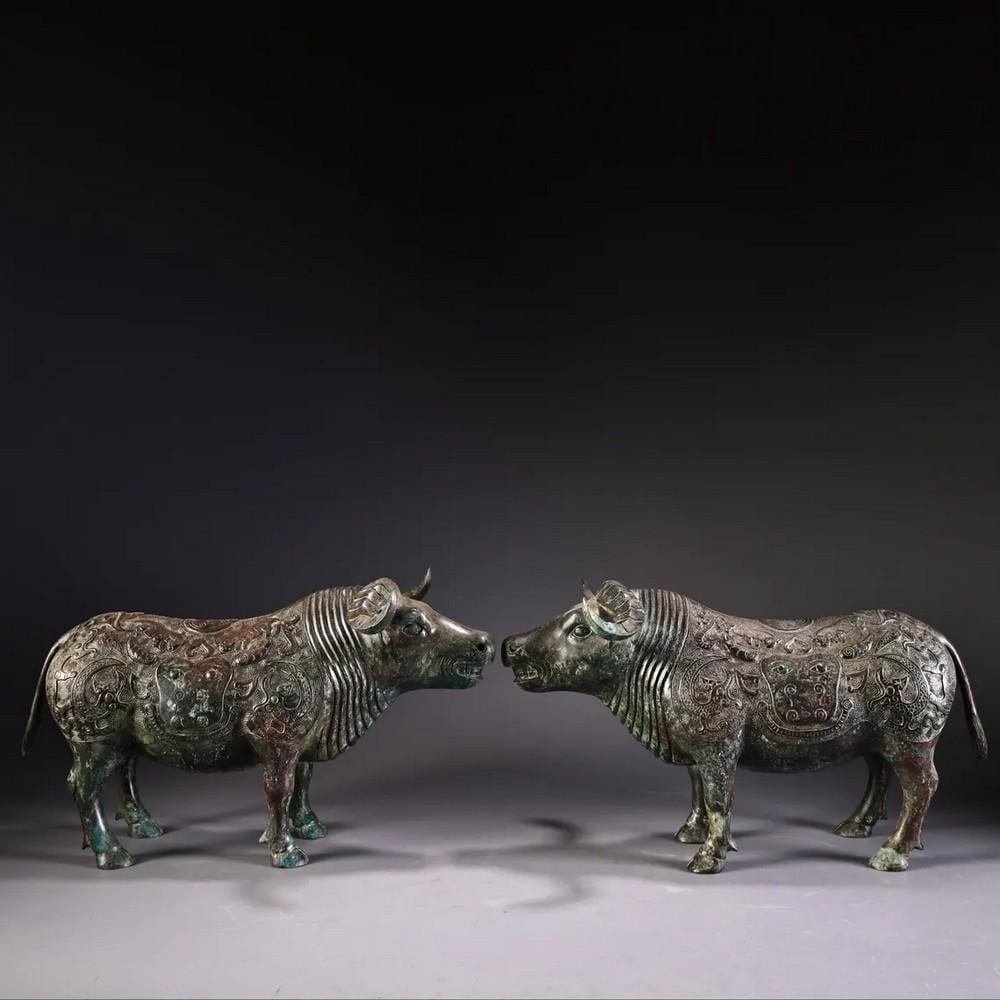 Antique Pair of Bronze Ox Statues: Antique Pair of Bronze Ox Statues This exceptional set of Chinese antique bronze ox statues is hand-crafted with intricate detail, showcasing refined artistry and cultural symbolism. Representing stre