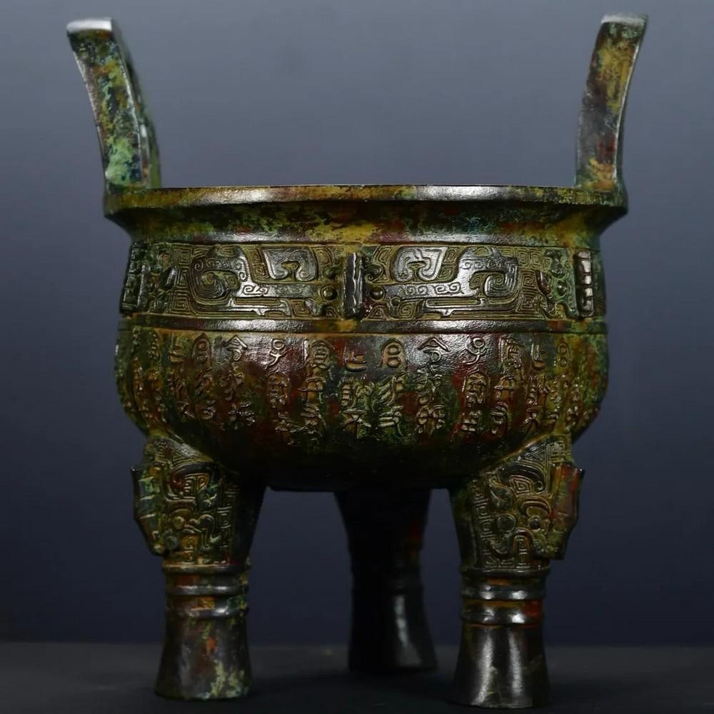 Antique Bronze Inscribed Tripod Statue: Antique Bronze Inscribed Tripod Statue This rare Chinese antique features a hand-crafted bronze tripod, intricately inscribed with traditional symbols and motifs. The sturdy, yet elegant design is a t