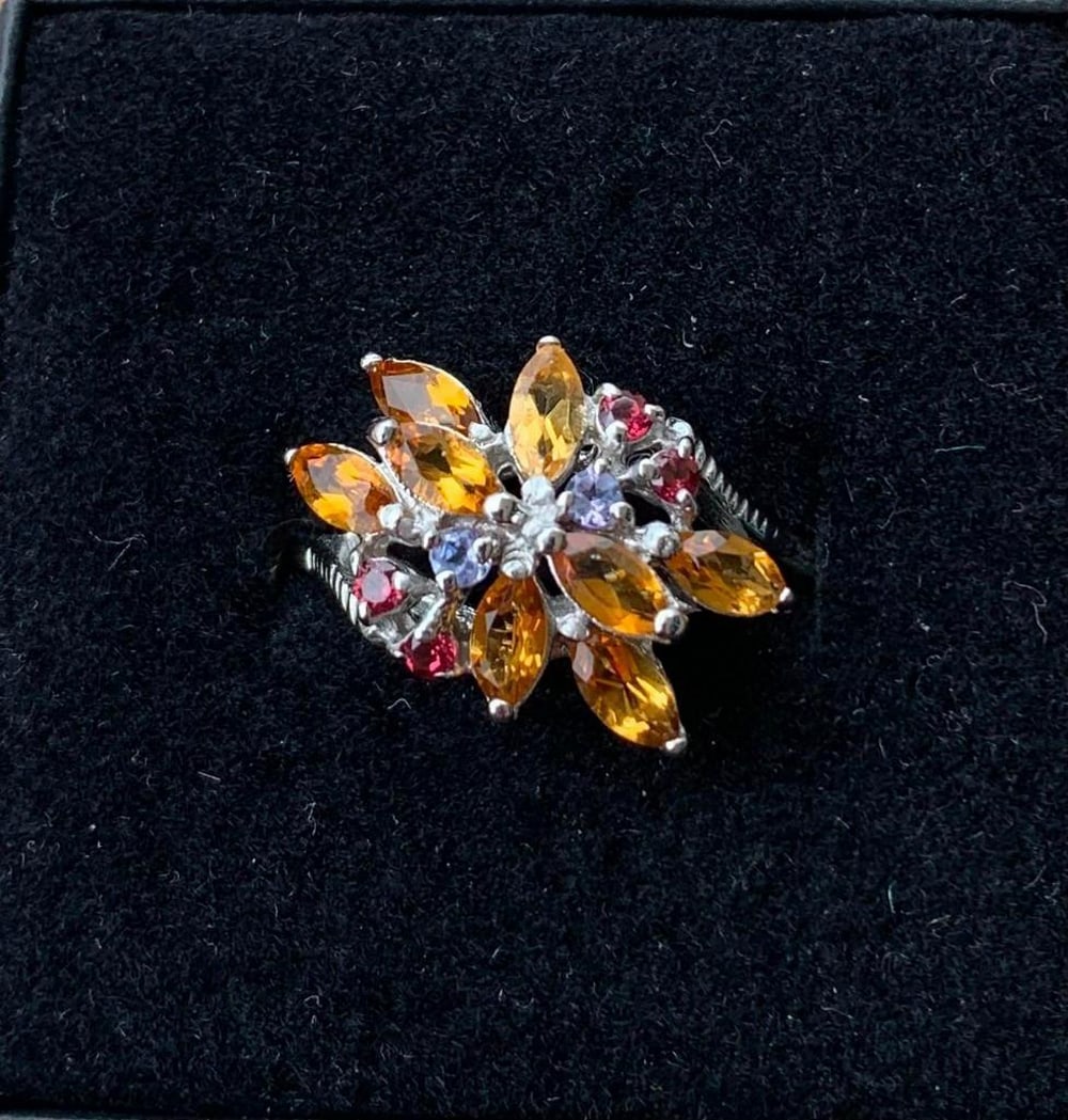 Sterling Silver Floral Ring with Mixed Gemstones: Sterling Silver Floral Ring with Mixed Gemstones Bursting with color and charm, this sterling silver ring features a stunning floral-inspired design crafted from a mix of orange, purple, and pink ston
