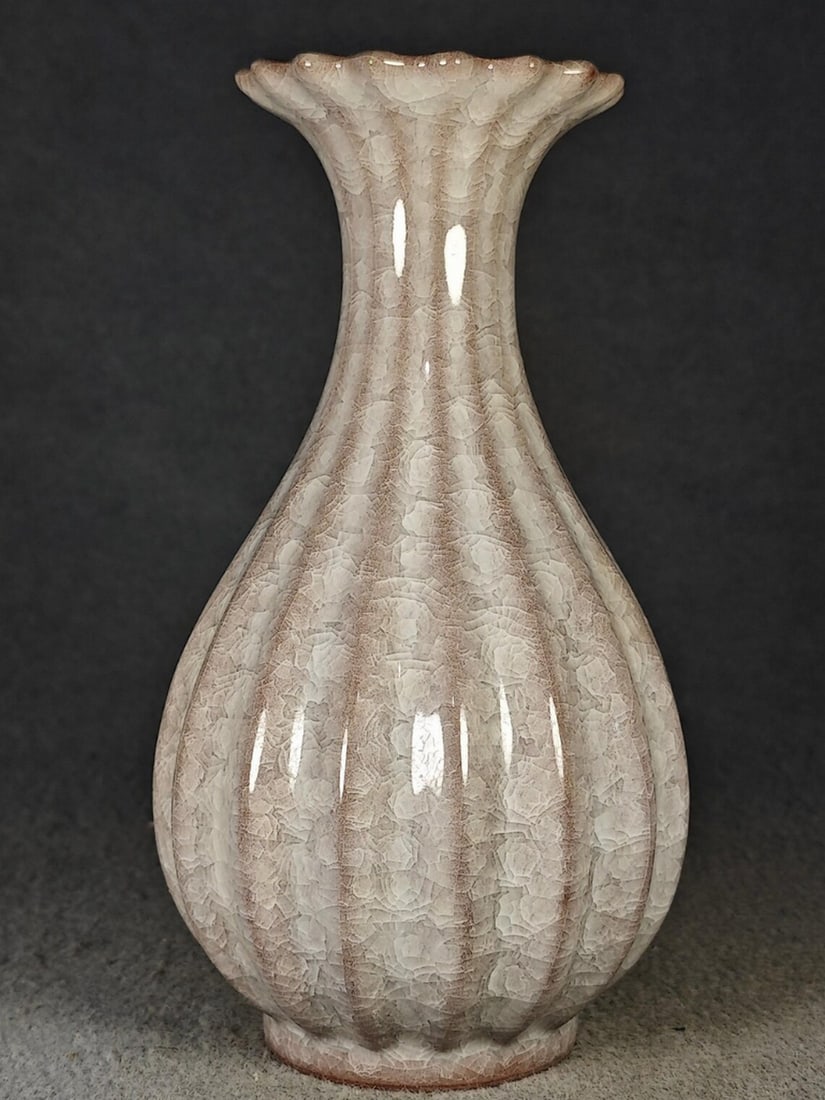 Chinese Style Carved Vase with Sliced Melon Edge Design: Chinese Style Carved Vase with Sliced Melon Edge Design This vase features a carved design with sliced melon-style edges in a Chinese-inspired form. The surface displays detailed craftsmanship with de