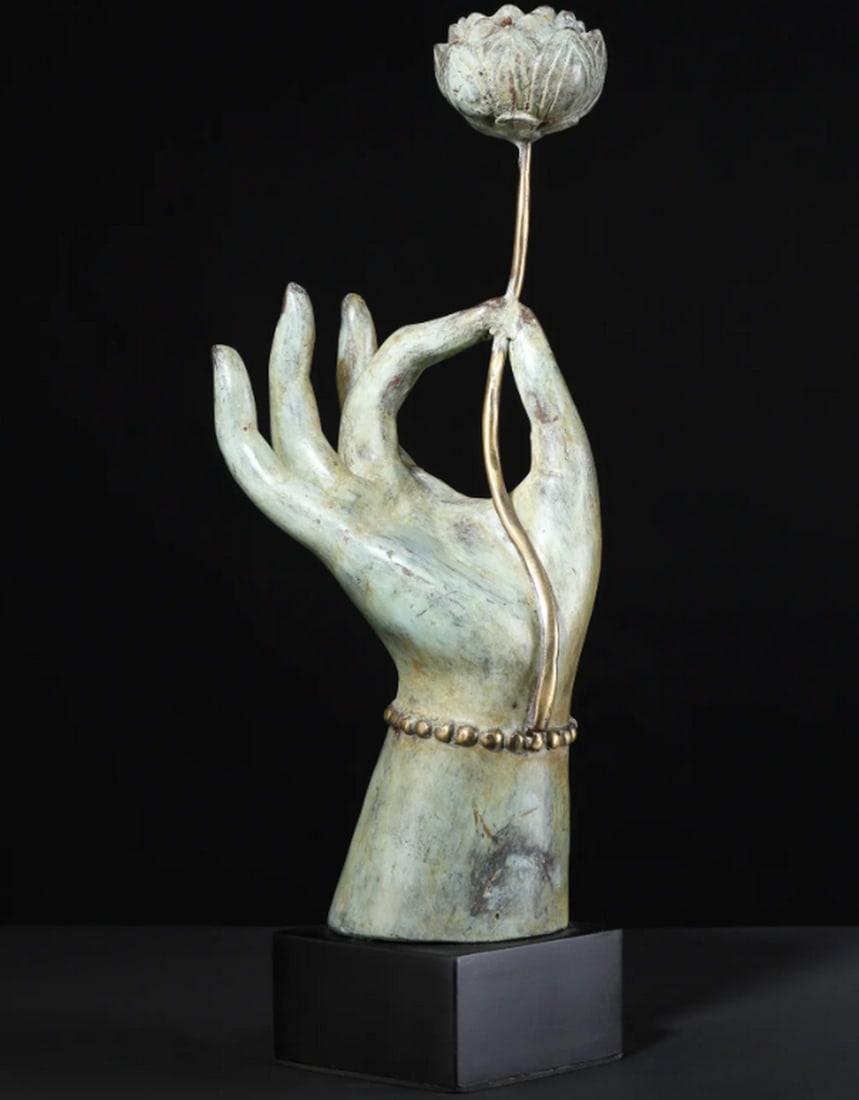 The Bloom of Buddhism – Table Décor with Tealight Holder: The Bloom of Buddhism – Table Décor with Tealight Holder A brass and wood table décor piece depicting Buddha’s hand holding a lotus blossom, symbolizing the awakening of wisdom. The hand forms