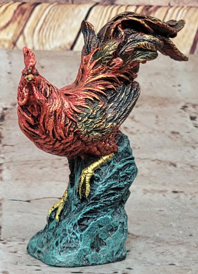 Patina Rooster Inspired Bronze Statue - 4" x 3.5": Patina Rooster Inspired Bronze Statue - 4" x 3.5" This striking bronze rooster sculpture captures the bird’s proud stance and vibrant plumage as it crows at dawn. Inspired by Greek mythology