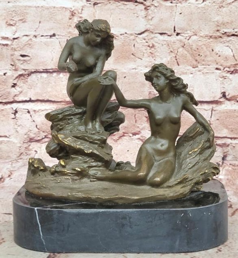 Gift of the Sea Bronze Sculpture: Gift of the Sea Bronze Sculpture A beautifully detailed bronze sculpture depicting two nude sea nymphs in a graceful and intimate moment by the shore. Seated on rocky outcrops, one nymph extends her h