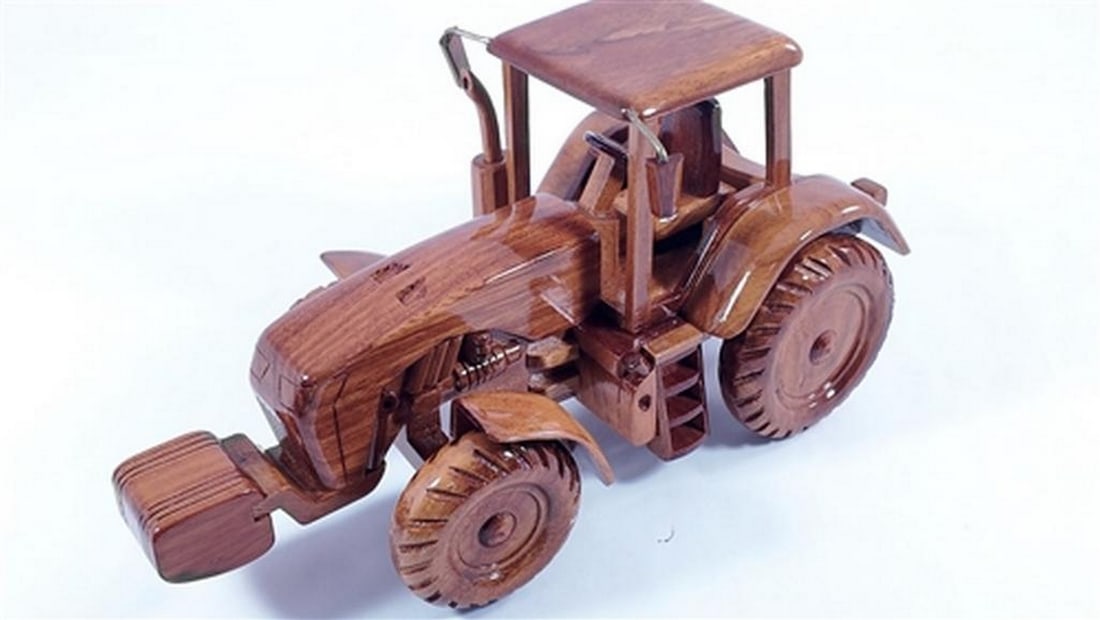 John Deere Tractor Wooden Model: John Deere Tractor Wooden Model This John Deere tractor is handcrafted from solid mahogany and finely detailed. The scale replica features turning wheels and is finished with three coats of