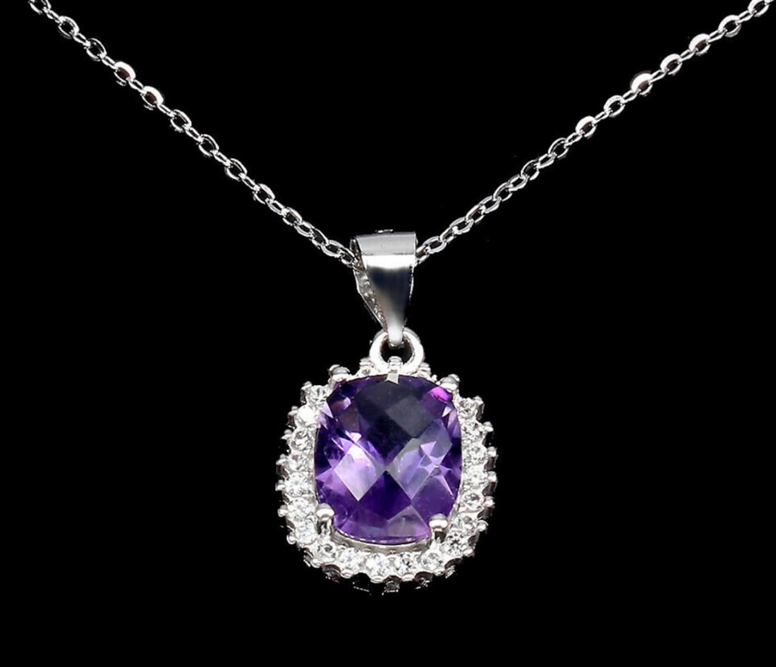 Enchanting Amethyst Cascade Necklace: Enchanting Amethyst Cascade Necklace This exquisite necklace features a stunning 10x8mm amethyst gemstone nestled within a sterling silver setting, embellished with dazzling zircon gemstones. The foca