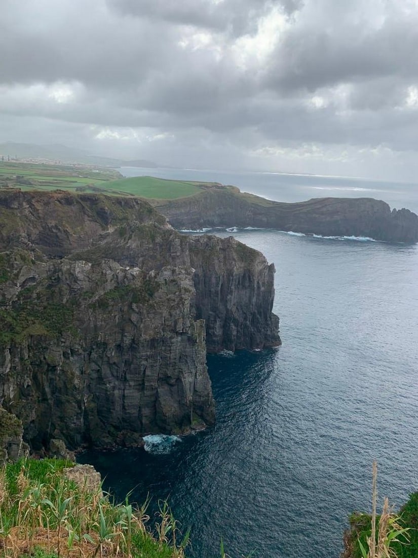 Island Cliffs: Island Cliffs Experience the sweeping beauty of an island coastline with this exclusive hand-painted canvas opportunity. The photograph captures a dramatic cliffside view overlooking the ocean, with
