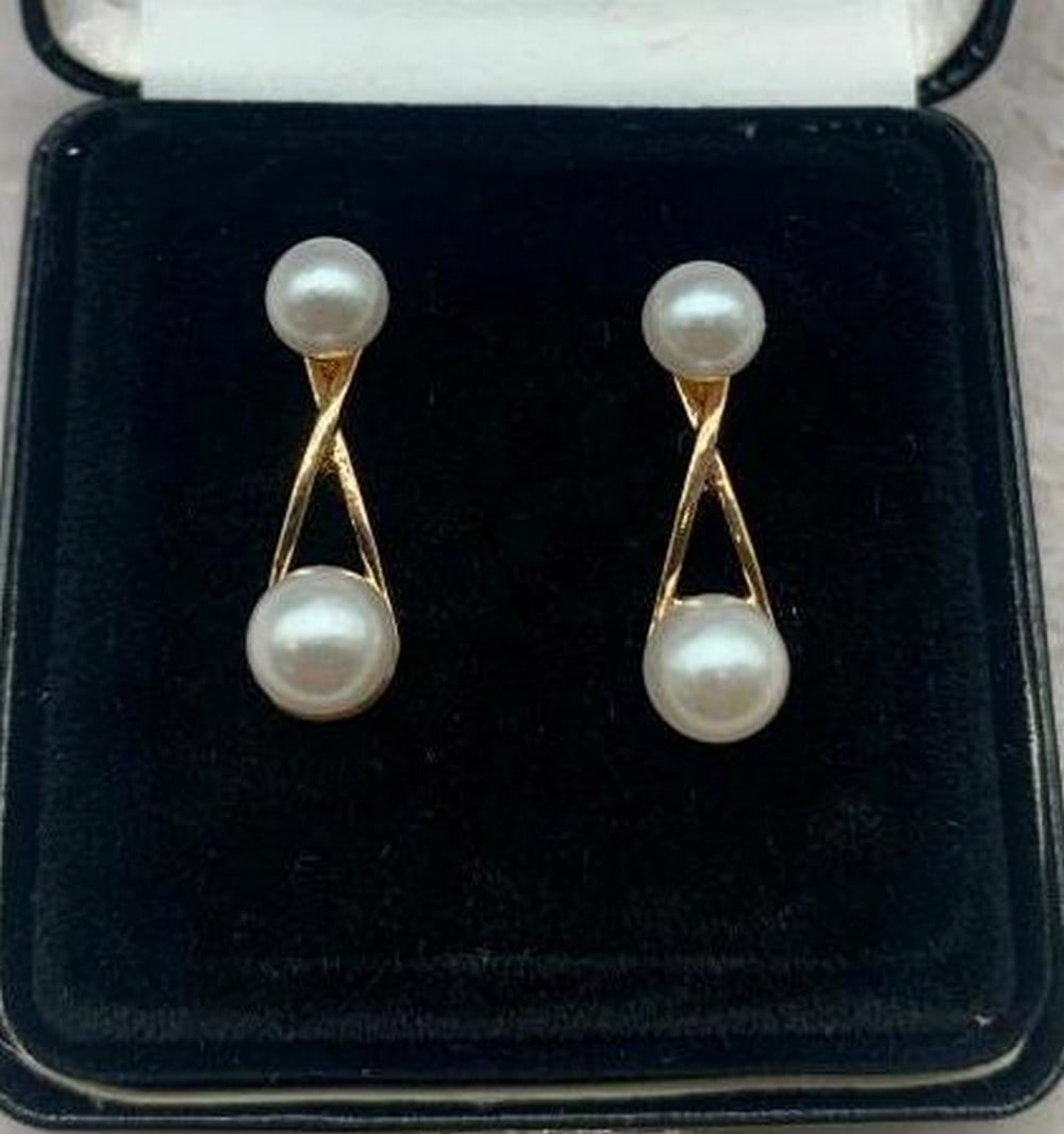 Double Pearl Criss-Cross Earrings: Double Pearl Criss-Cross Earrings Gracefully modern with timeless charm, these earrings feature two luminous pearls, one delicately placed at the top and another suspended below, connected by an