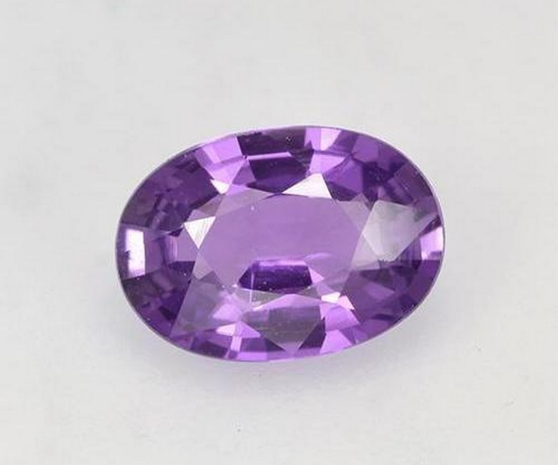 0.78 ct Oval Vivid Violet Sapphire: 0.78 ct Oval Vivid Violet Sapphire Introducing the Oval Vivid Violet Sapphire, a natural gemstone weighing 0.78 carats. This heated sapphire from Madagascar displays a rich violet hue of AAA color qua