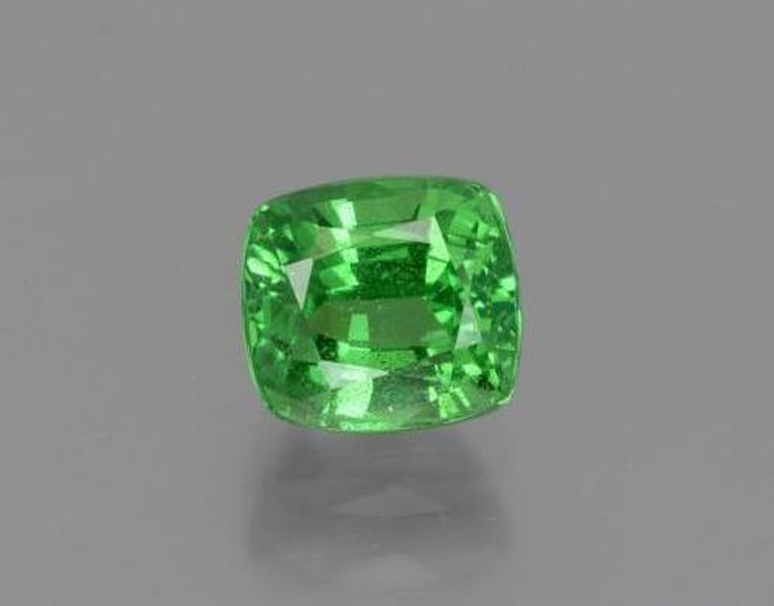 1.18 ct Cushion Natural Electric Green Tsavorite Garnet: 1.18 ct Cushion Natural Electric Green Tsavorite Garnet This natural 1.18-carat tsavorite garnet from Tanzania is cut in a classic cushion shape, showcasing a vivid electric green color with lively br