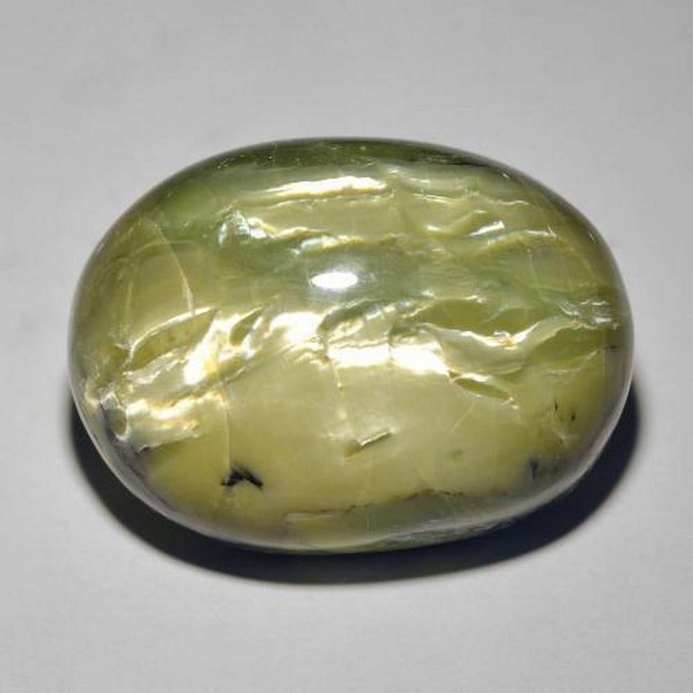 39.2 ct Oval Cabochon Pale Chartreuse Green Cat's Eye Opal: 39.2 ct Oval Cabochon Pale Chartreuse Green Cat's Eye Opal Introducing our Oval Cabochon Pale Chartreuse Green Cat's Eye Opal, a gemstone of ethereal charm. Its captivating cat's eye effect adds a mes