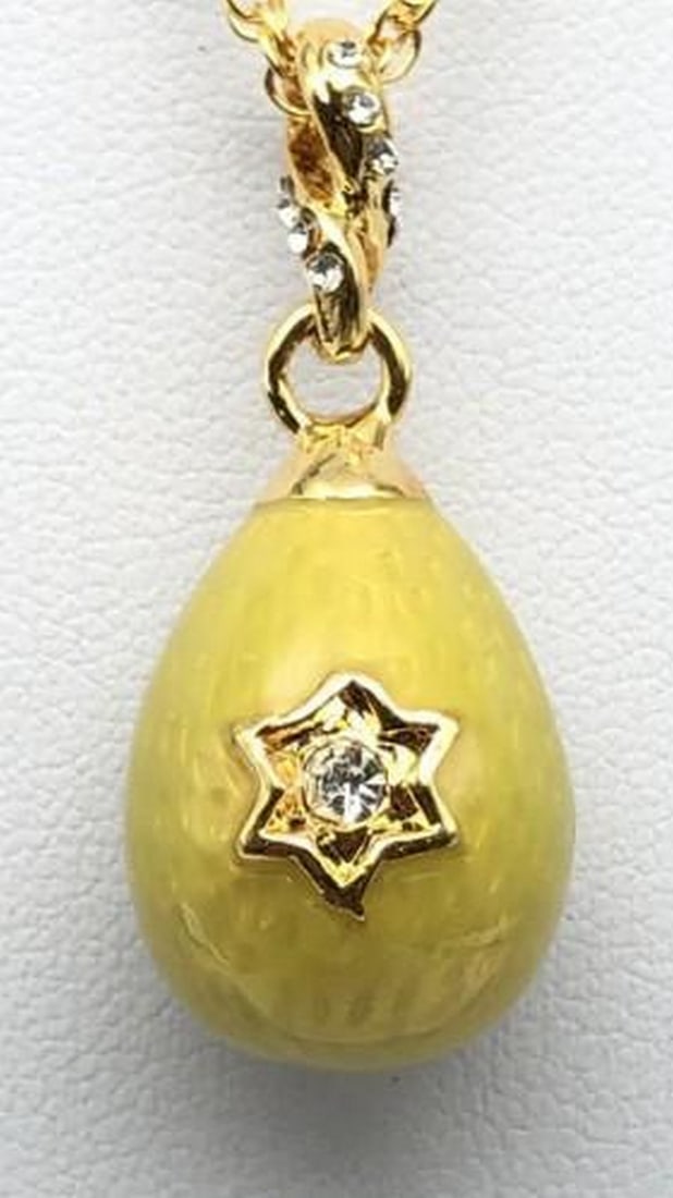 Golden Star of David Yellow Egg Pendant Necklace: Golden Star of David Yellow Egg Pendant Necklace This radiant yellow egg pendant is adorned with a delicate Star of David, symbolizing faith and tradition. The glossy enamel finish glows with warmth, 