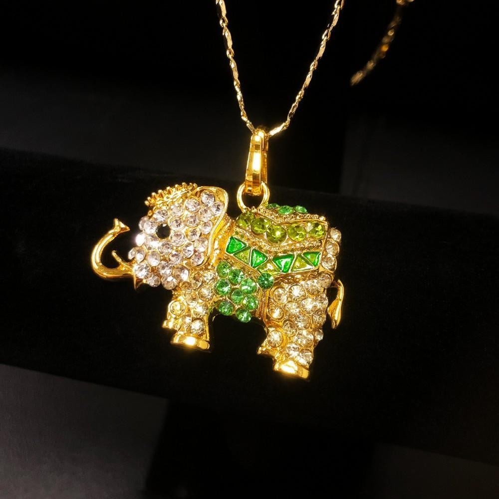 Bejeweled Green And Gold Rhinestone Ganesh Chaturthi Elephant Pendant Paired With Necklace Marked: Bejeweled Green And Gold Rhinestone Ganesh Chaturthi Elephant Pendant Paired With 18kt Gold Plated Necklace. Comes with a Chinese Window Shade Box. View Photos For Further Details.