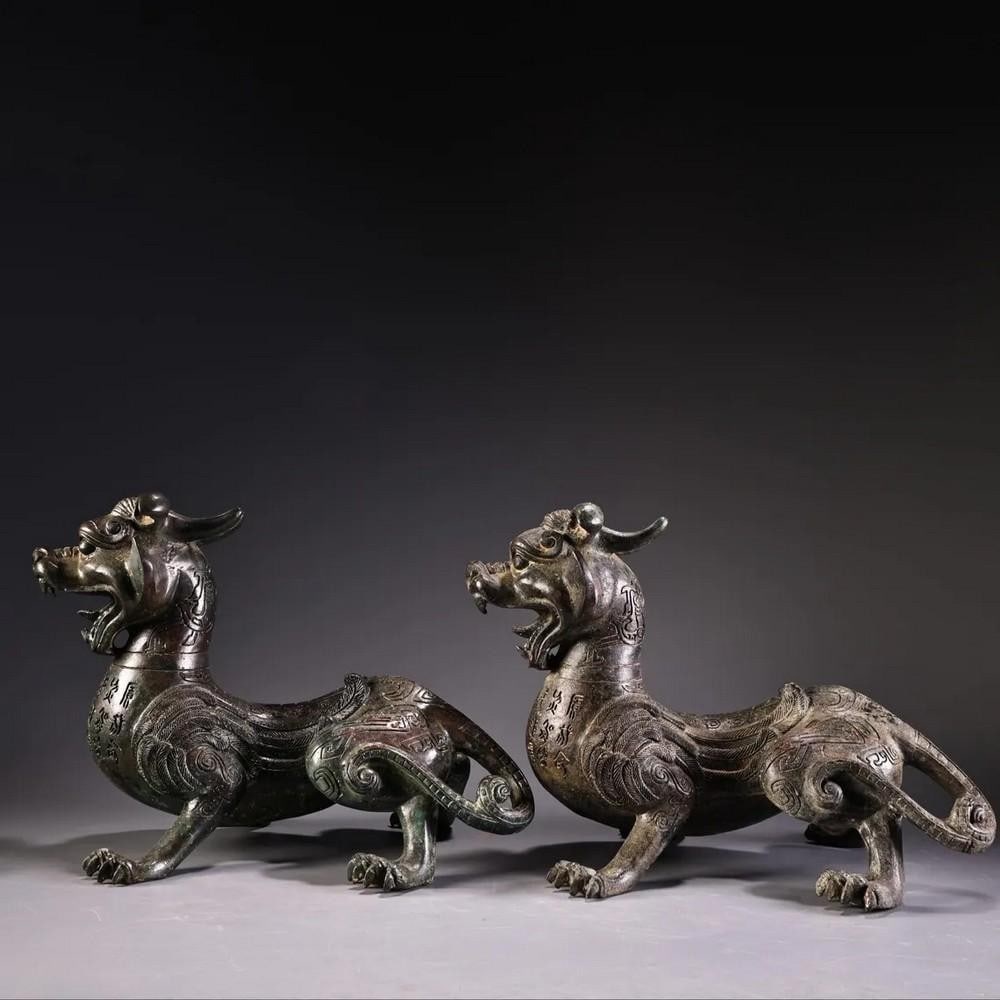 Pair of Antique Bronze Inscribed Animal Statues: Pair of Antique Bronze Inscribed Animal Statues This rare Chinese antique features a hand-crafted pair of bronze animals with intricate inscriptions, showcasing exquisite artistry and attention to