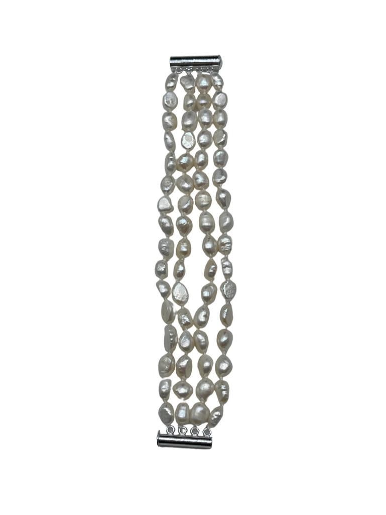 Natural White Baroque 4-Strand Freshwater Pearl Bracelet: Natural White Baroque 4-Strand Freshwater Pearl Bracelet. Natural Silver Glimmers Come Off Each Of The 7-8mm Pearls. There are 60+ Pearls On This 4 Strand Bracelet and Is Accompanied By A Push Tube