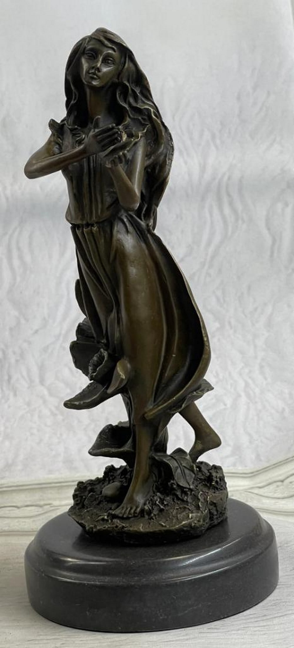 J. Mavchi Original Reclining Woman with Floral Motif Bronze Sculpture - 10.5" x 4.5": J. Mavchi Original Reclining Woman with Floral Motif Bronze Sculpture - 10.5" x 4.5" This original bronze sculpture depicts a reclining woman resting against a tree stump, surrounded by flowin