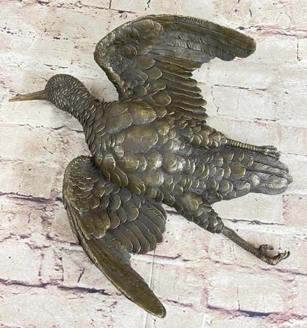 Wings of Time: Bronze Flying Bird Wall Sculpture: Wings of Time: Bronze Flying Bird Wall Sculpture Gracefully suspended in mid-flight, this vintage cast wall hanging bronze captures the timeless beauty of a bird soaring through the air. It is bearing