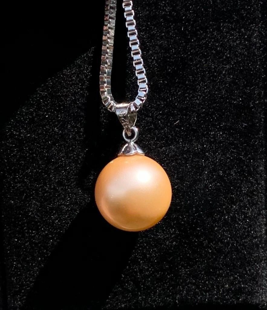Sterling Silver Necklace with Soft Beige Pearl Pendant: Sterling Silver Necklace with Soft Beige Pearl Pendant A timeless sterling silver chain necklace featuring a beige-hued pearl pendant. The pearl's subtle warmth and sheen offer a refined, understated