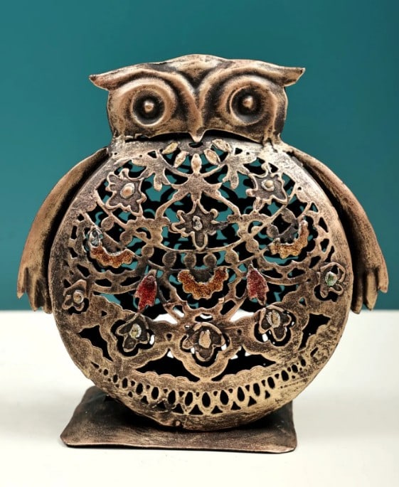 7'' Owl Standing Candle Stand: 7" Owl Standing Candle Stand Handmade from iron, this candle stand is shaped in the form of an owl, symbolizing wisdom and presence. The design combines decorative detail with functional use, offer