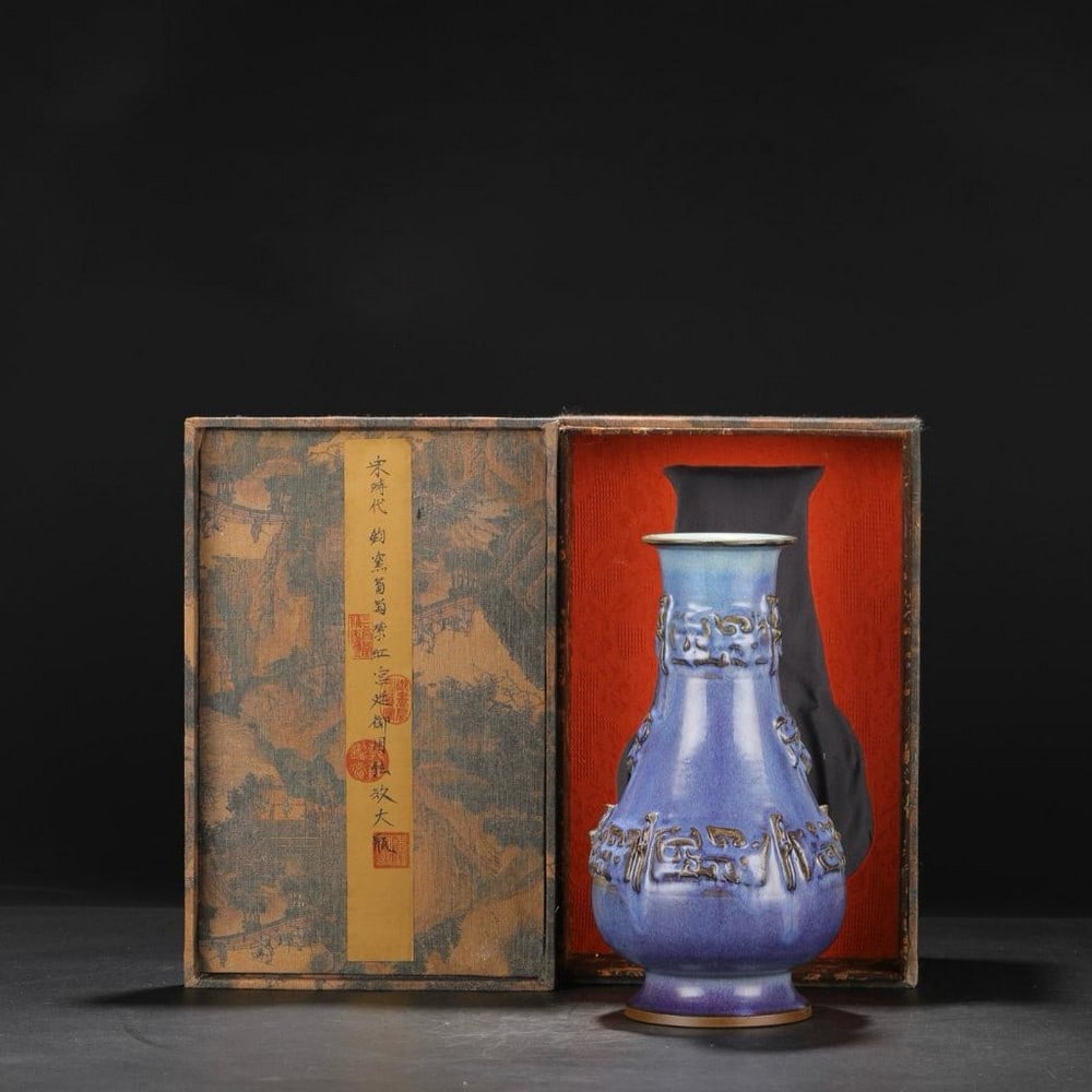 Inspired Northern Song Jun-Style Blue Glaze Vase: Inspired Northern Song Jun-Style Blue Glaze Vase Inspired by the refined elegance of the Northern Song Dynasty's Jun kiln, this vase showcases a serene blue glaze. Delicate carvings in a warm copper h