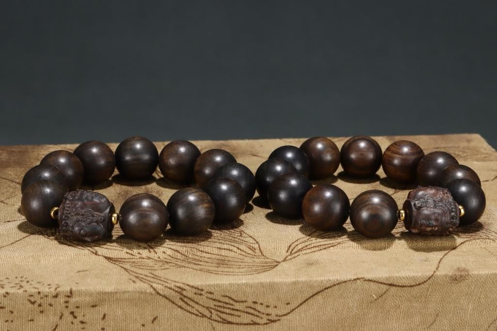 Inspired Old Palace Collection Agarwood Bracelet with Three-Sided Guanyin: Inspired Old Palace Collection Agarwood Bracelet with Three-Sided Guanyin An exquisite agarwood bracelet inspired from an old palace collection, featuring a lustrous finish and intricately carved thre