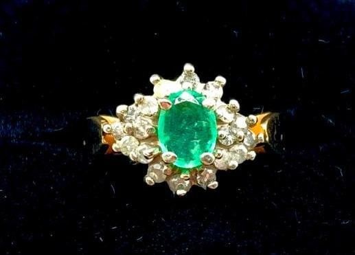 14K Gold Ring set with Oval Cut Emerald & Cubic Zirconia: 14K Gold Ring set with Oval Cut Emerald & Cubic Zirconia This ring is set with a 0.24ct Emerald stone and is surrounded by 18 round cut Cubic Zirconia stones. Dimensions of Emerald: 5.3 x 3.5 x 2.3mm 