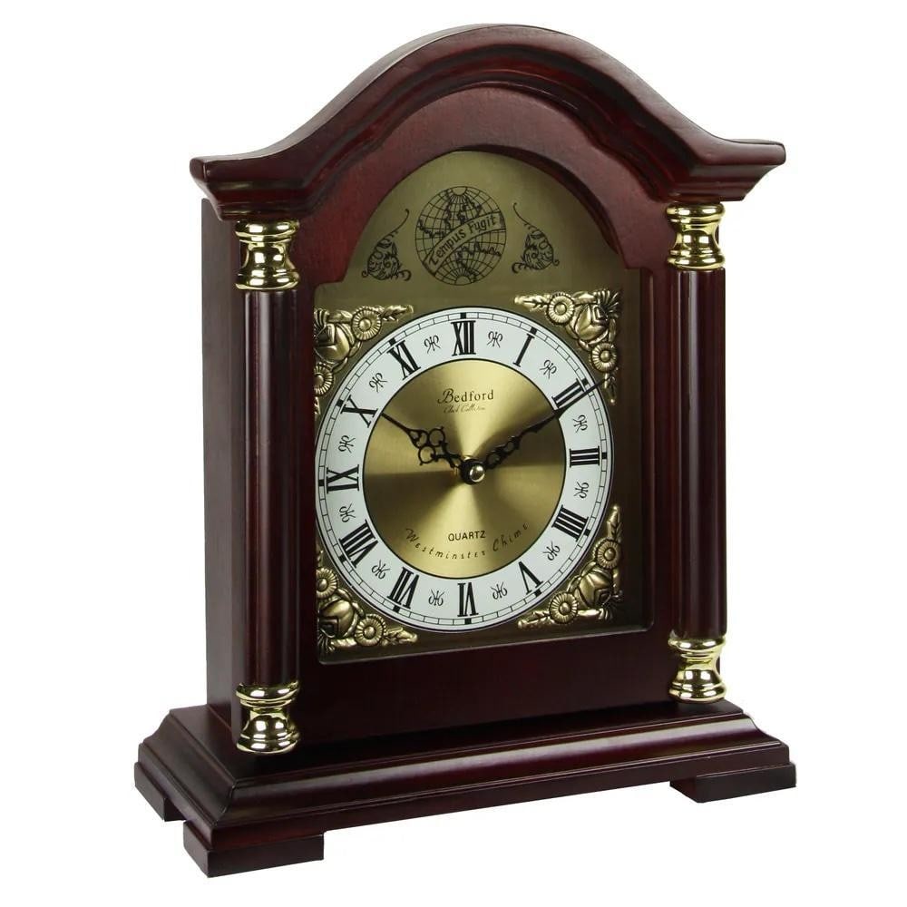 Timeless Redwood Oak Mantel Clock with Hourly Chimes: Timeless Redwood Oak Mantel Clock with Hourly Chimes This elegant mantel clock features a redwood oak-finished wooden case with a glass-enclosed dial. The bright dial highlights Roman numerals with