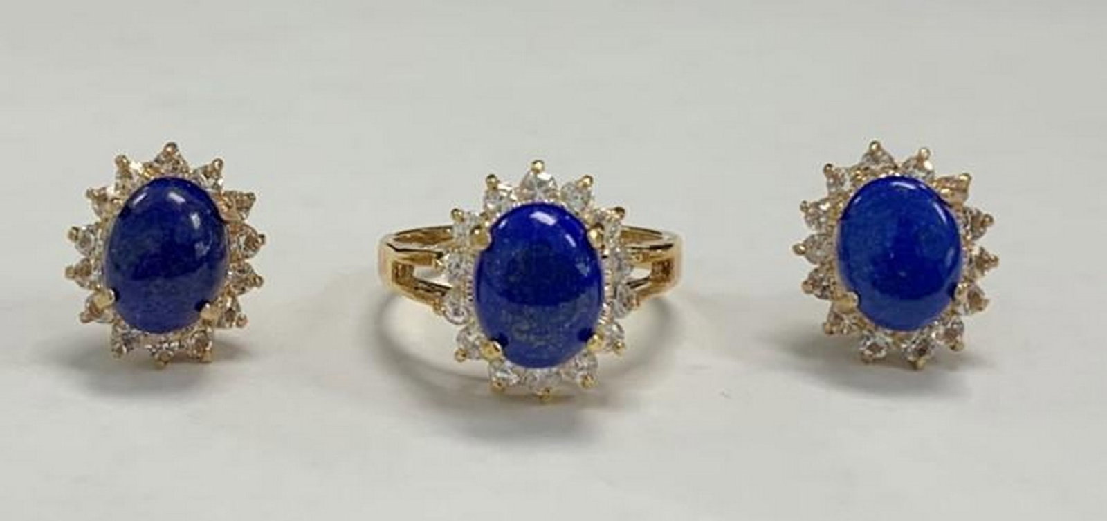 Royal Radiance: Sapphire and White Topaz Jewelry Set: Royal Radiance: Sapphire and White Topaz Jewelry Set This exquisite jewelry set features a captivating trio - a ring and matching earrings - each adorned with a deep blue oval-cut gemstone, encircled 