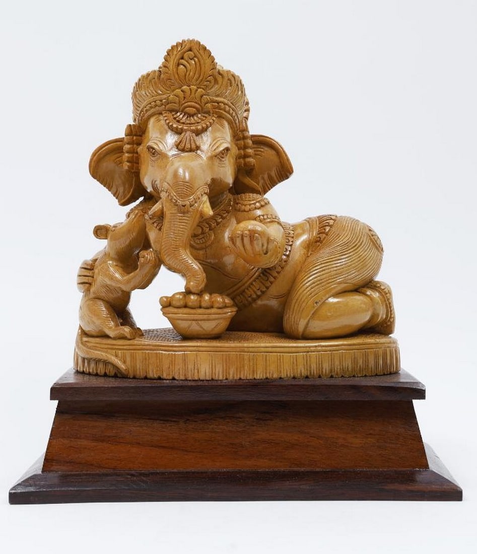 11" Bal Ganesha Eating Modak with Mushak Wood Carved Statue: 11" Bal Ganesha Eating Modak with Mushak Wood Carved Statue This beautifully handcrafted wooden statue depicts Bal Ganesha in a joyful moment, enjoying a modak while his loyal companion Mushak sit