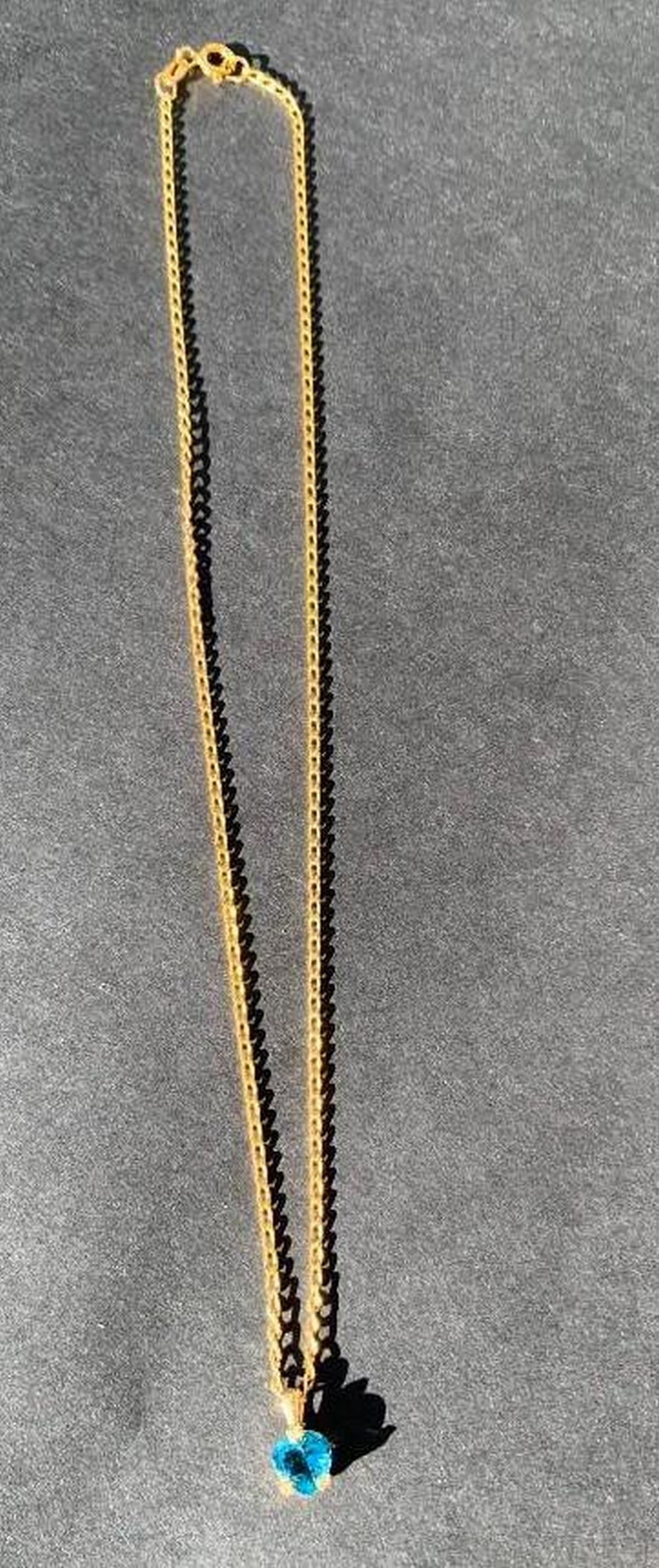 Gold-Plated Necklace with Blue Heart Pendant: Gold-Plated Necklace with Blue Heart Pendant Express your style and sentiment with this elegant gold-plated necklace, featuring a charming blue heart-shaped pendant. The vibrant blue stone adds a pop 