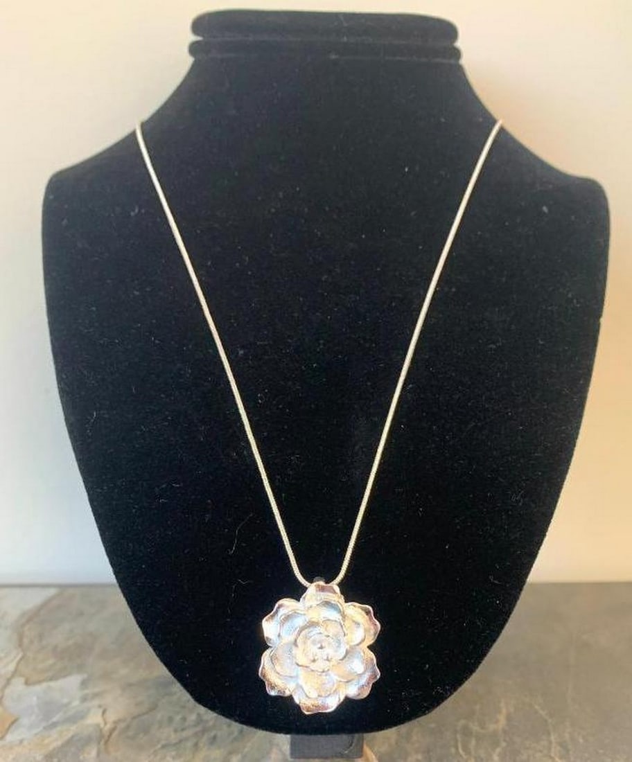 Radiant Bloom Silver Floral Pendant: Radiant Bloom Silver Floral Pendant Elegant and timeless, this stunning silver necklace features a beautifully sculpted floral pendant that captures the delicate essence of a blooming flower. Each
