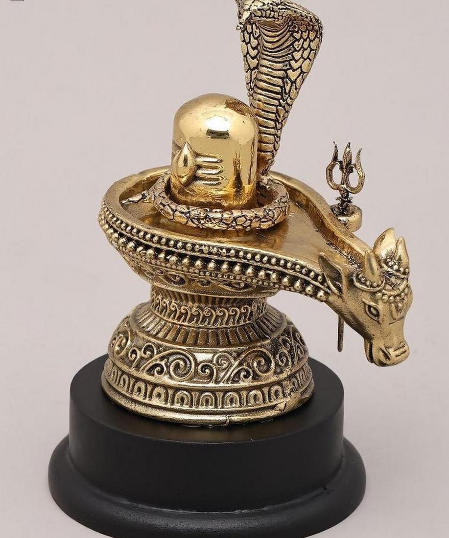 5" Shiva Lingam with Nandi, Trident, and Vasuki Naag on Wooden Base: 5" Shiva Lingam with Nandi, Trident, and Vasuki Naag on Wooden Base This 5" brass statue beautifully depicts the Shiva Lingam, symbolizing the formless and infinite nature of Lord Shiva, accom