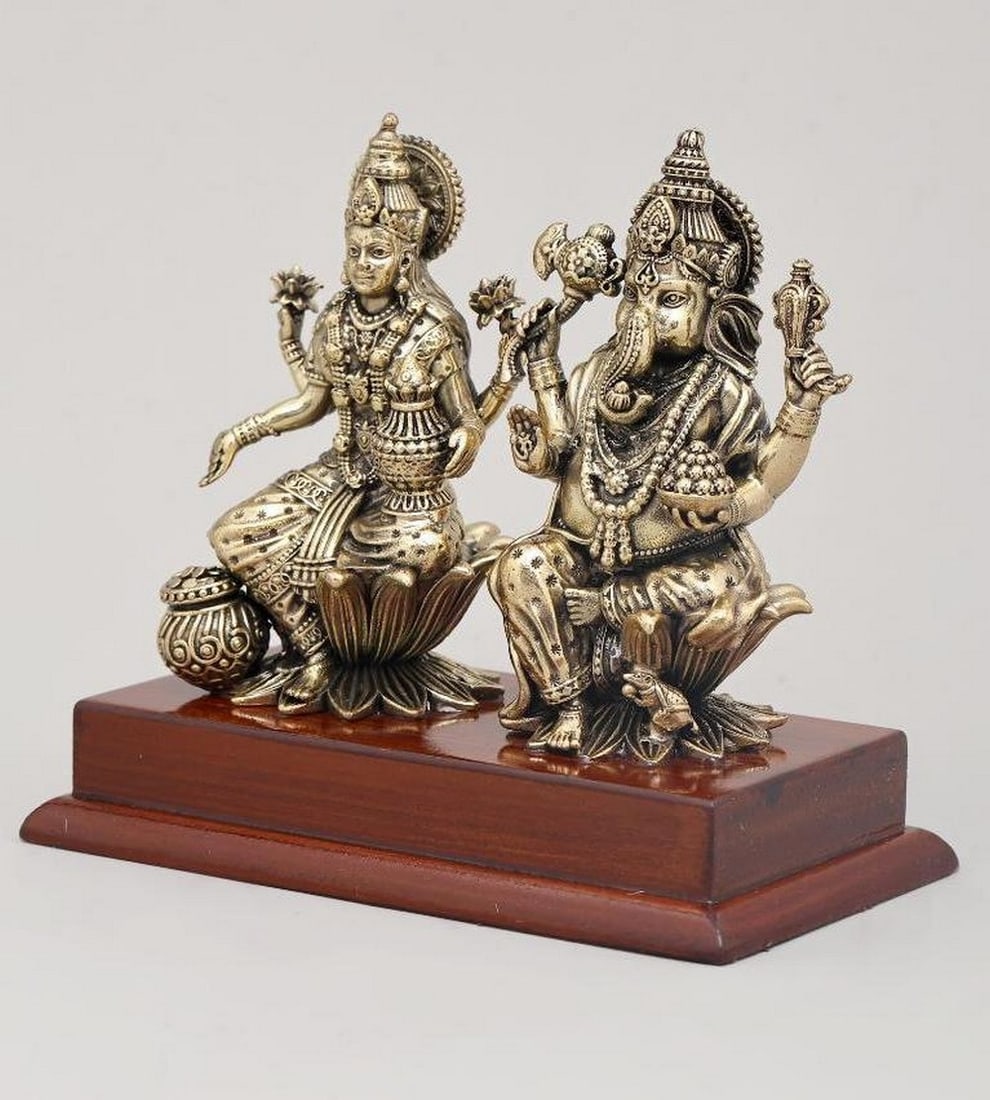 5" Small Brass Idol of Goddess Lakshmi and Lord Ganesha Seated on Wood Base: 5" Small Brass Idol of Goddess Lakshmi and Lord Ganesha Seated on Wood Base This 5" brass idol features Goddess Lakshmi, the goddess of wealth and prosperity, and Lord Ganesha, the remover of 