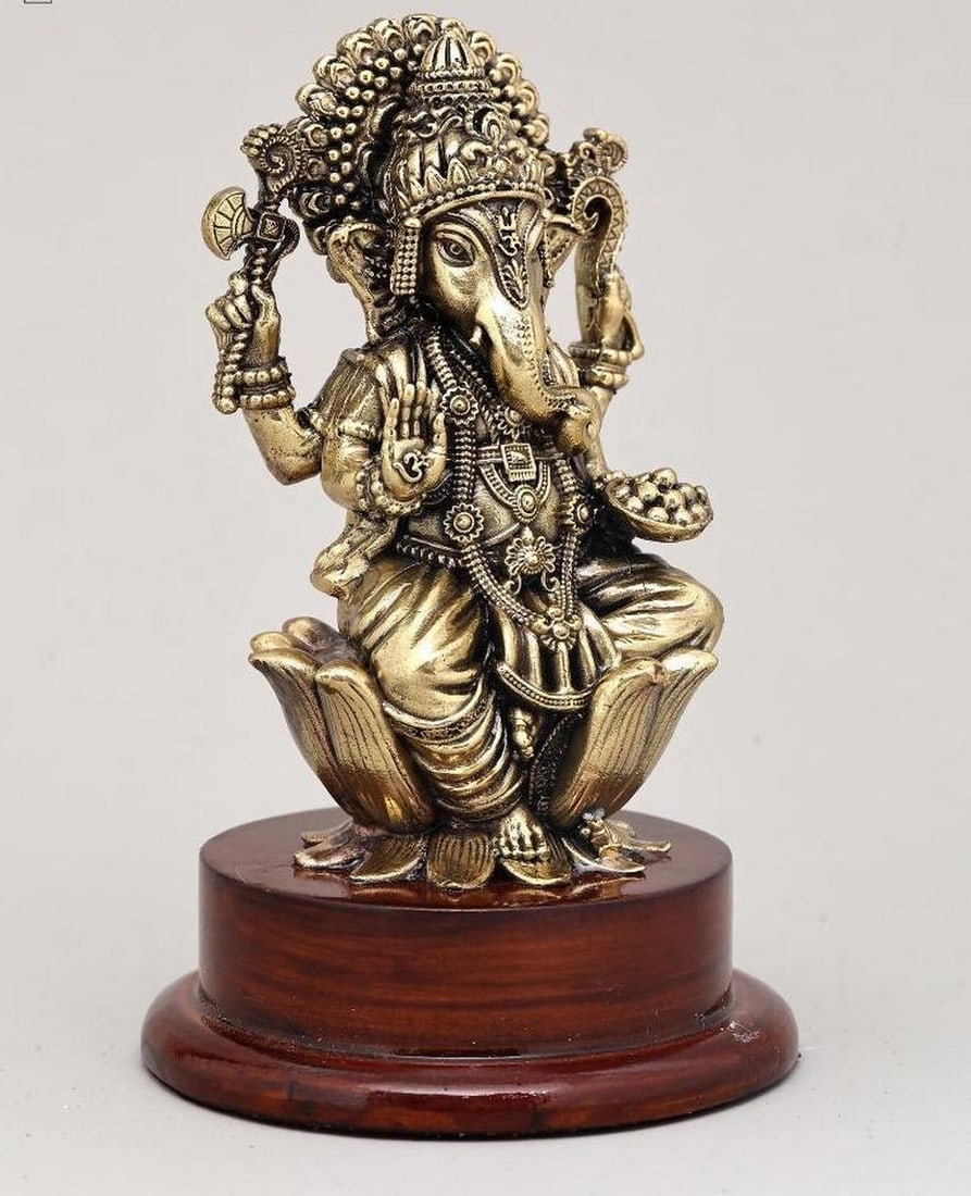 5" Brass Lord Ganesha Seated in Blessing Pose: 5" Brass Lord Ganesha Seated in Blessing Pose This 5" brass idol features Lord Ganesha, the remover of obstacles and god of beginnings, seated gracefully on a lotus. His upper hands hold a bat