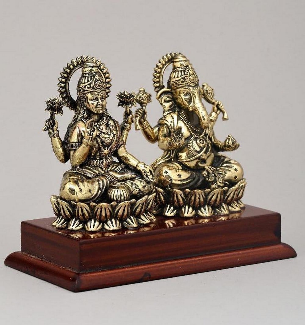 5" Brass Goddess Lakshmi and Lord Ganesha Seated on Lotus: 5" Brass Goddess Lakshmi and Lord Ganesha Seated on Lotus This 5" brass statue depicts Goddess Lakshmi and Lord Ganesha seated on lotus flowers, symbolizing wealth, wisdom, and auspicious begi