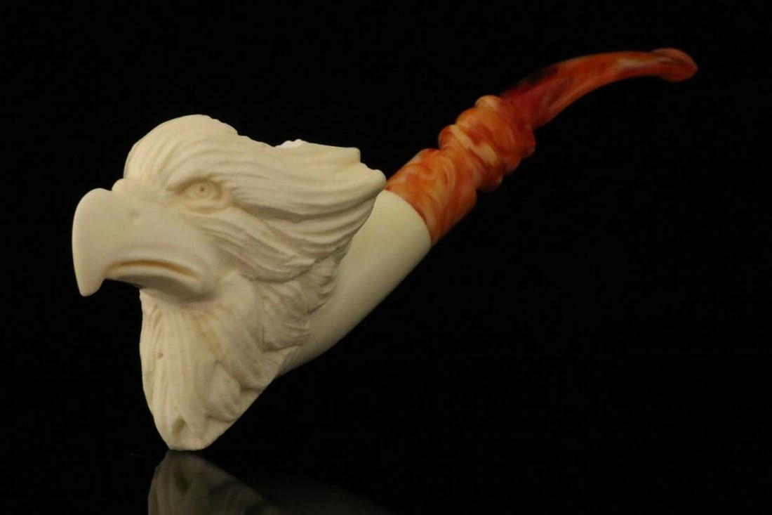 Eagle Carved Meerschaum Pipe with Fitted Case: Eagle Carved Meerschaum Pipe with Fitted Case This hand-carved meerschaum pipe features a detailed eagle design, highlighting the fine craftsmanship and artistry of traditional meerschaum work. It com