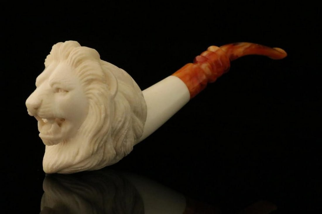 Carved Lion Meerschaum Pipe with Protective Case: Carved Lion Meerschaum Pipe with Protective Case This hand-carved meerschaum pipe features a majestic lion design, showcasing the artistry and fine craftsmanship of traditional meerschaum work. It
