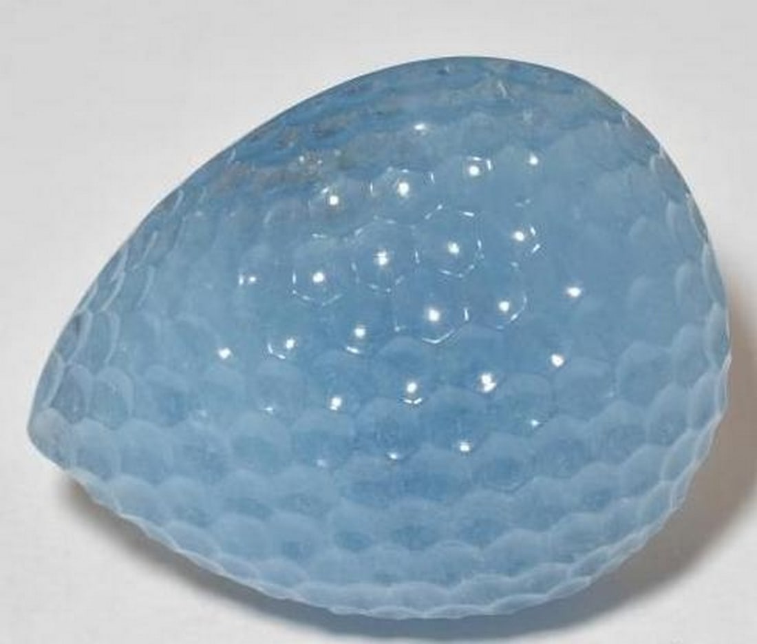 Swiss Blue Aquamarine Pear-Cut Gemstone with Textured Carving: Swiss Blue Aquamarine Pear-Cut Gemstone with Textured Carving This striking loose gemstone is crafted from vivid Swiss Blue aquamarine and shaped into a graceful carved pear. Its surface features a