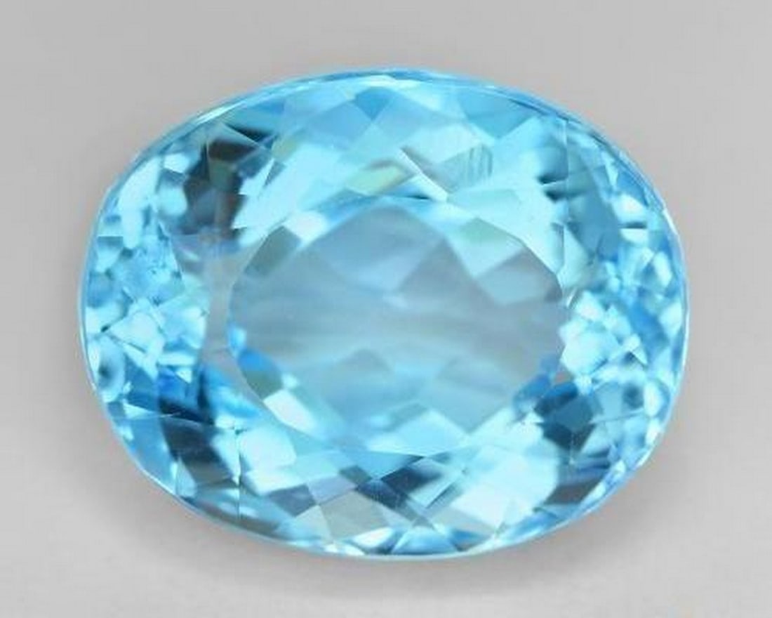 27.35 ct Natural Swiss Blue Topaz, Oval Facet, VVS, Brazil: 27.35 ct Natural Swiss Blue Topaz, Oval Facet, VVS, Brazil Large natural topaz weighing 27.35 carats, cut in an oval facet with vivid Swiss blue color. The gem measures 18.58 x 15.00 x 11.56 mm and