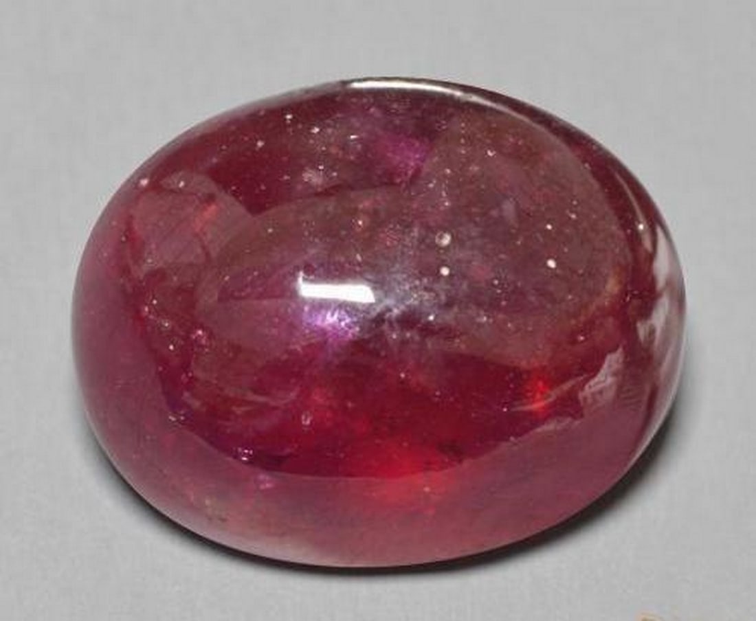 25.56ct Natural Deep Red Ruby, Oval Cabochon, Translucent, Madagascar: 25.56ct Natural Deep Red Ruby, Oval Cabochon, Translucent, Madagascar A single natural ruby gemstone weighing 25.56 carats, cut in a smooth oval cabochon shape with a deep red color and translucent cl