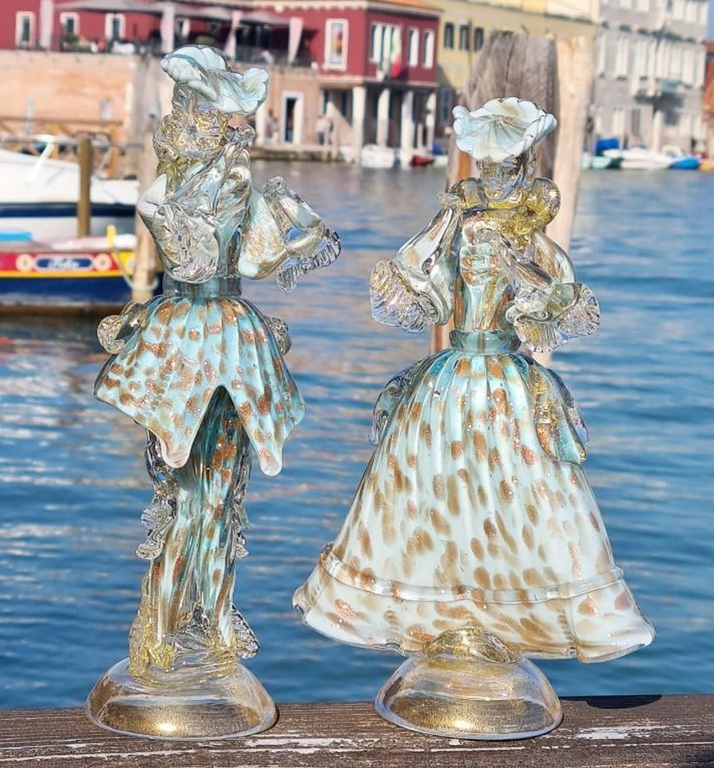 Goldoni Couple Murano Glass Figurines: Goldoni Couple Murano Glass Figurines Inspired by the elegance of 18th-century Venetian theater, this Goldoni couple is masterfully handcrafted in Murano glass. Dressed in light blue garments adorned