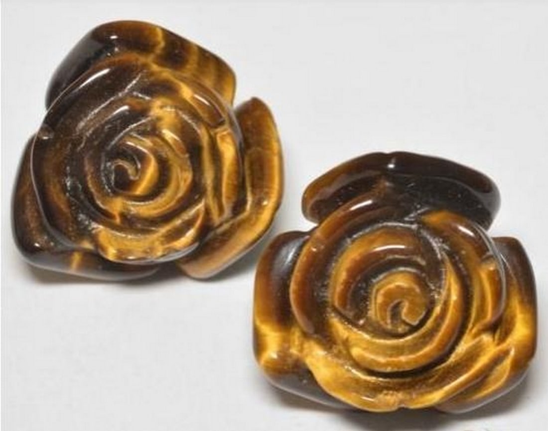 Pair of Hand-Carved Golden Brown Tiger's Eye Rose Gemstones: Pair of Hand-Carved Golden Brown Tiger's Eye Rose Gemstones This captivating pair of gemstones is intricately carved into delicate rose blooms, each fashioned from shimmering golden brown tiger's